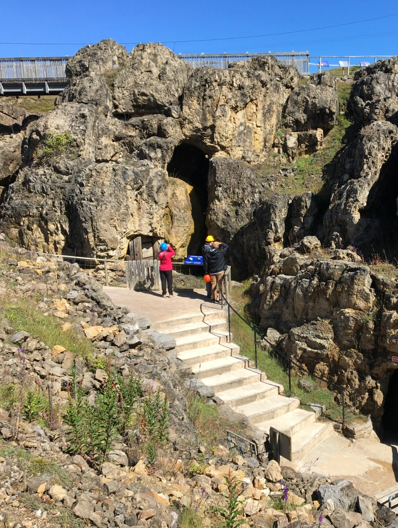People looking at the rocks near the entrance to an underground mine.