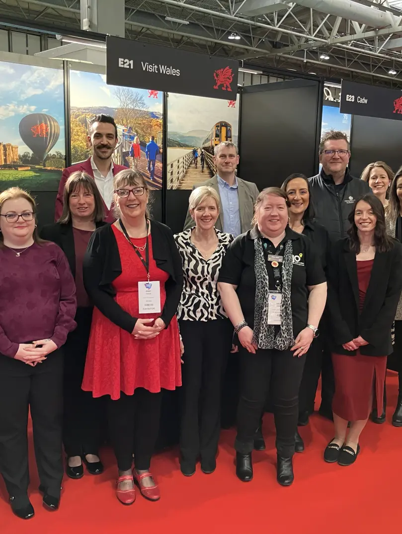 A group of people at a trade show smiling at the camera.