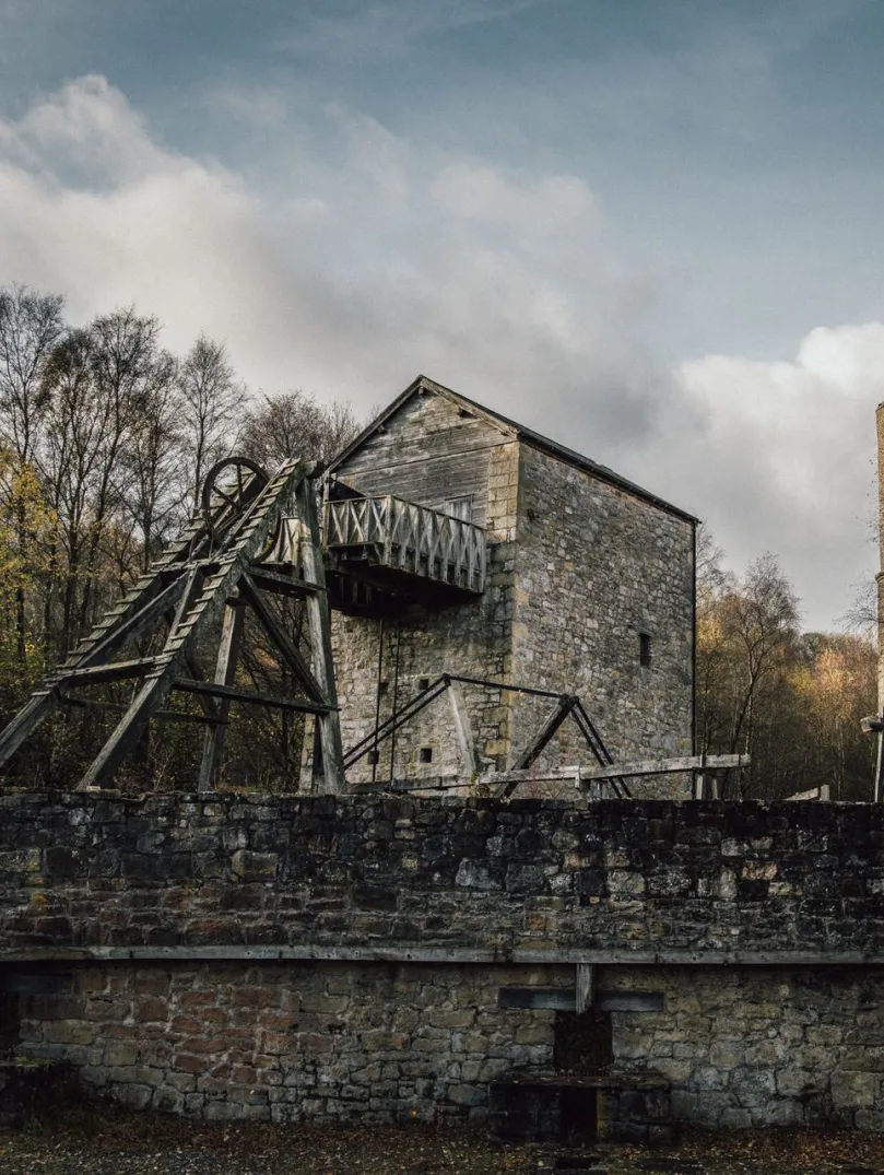 A winding wheel and chimney in a lead mine attraction.