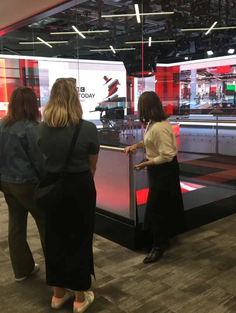 Group on a tour with a guide at a broadcasting studio.
