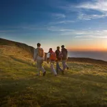 Four walkers enjoying the sunset along the Glamorgan Heritage Coast.