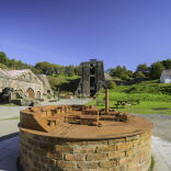 A small scale model of the ironworks at Blaenavon, with real site behind it.
