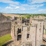 The ruins of a castle with views of the countryside beyond.