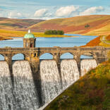 Craig Goch dam and reservoir with autumn colours on the hills beyond in the Elan Valley.