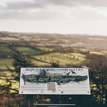 A viewpoint of Merlin's Hill with a sign detailing what you can see beyond.