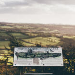 A viewpoint of Merlin's Hill with a sign detailing what you can see beyond.