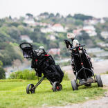 Golfing trolleys with Langland Bay in the background.