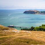 Views of the promenade, coastline, pier and cable cars from a high vantage point.