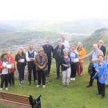 A group of people standing on a mountain on a tour of the valleys.