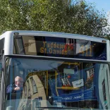 A bus picking up passengers.