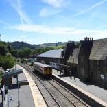 A train pulling into a station on a sunny day.