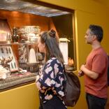 A couple looking at exhibitions in a glass case in a museum.