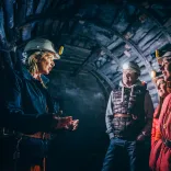 A tour guide talking to visitors in a former underground mine.