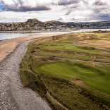 Aerial shot a a golf course by the sea.