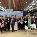 Group of people at a trade show smiling at the camera.
