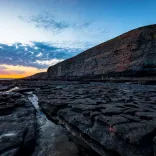 A rocky coastline and cliffs during sunset.