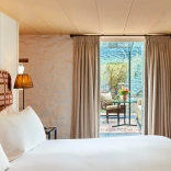 Bedroom suite leading out to a balcony with table and chairs.
