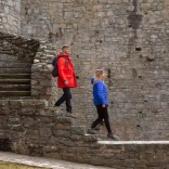A couple walking down the steps in a castle.