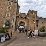 People walking into the entrance of a castle.