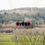 Group of people on a giant swing in an adrenaline fuelled forest attraction.