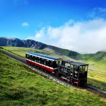 A steam train going up a mountain.