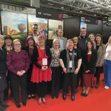 A group of people at a trade show smiling at the camera.