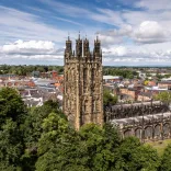 Aerial shot of a medieval church with the city beyond.