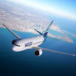 An aircraft in the sky above the sea.