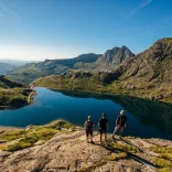Group of walkers overlooking a lake on the top of a mountain.
