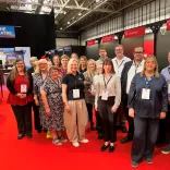 Group of people at a trade show smiling at the camera