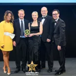 Group of people with an award posing for the camera.