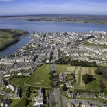 Aerial shot of a town, castle and shoreline.