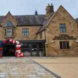 Frontage of a refurbished museum adorned with balloons on the doorway.