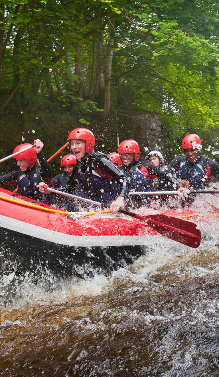 A group of people whitewater rafting down a river.