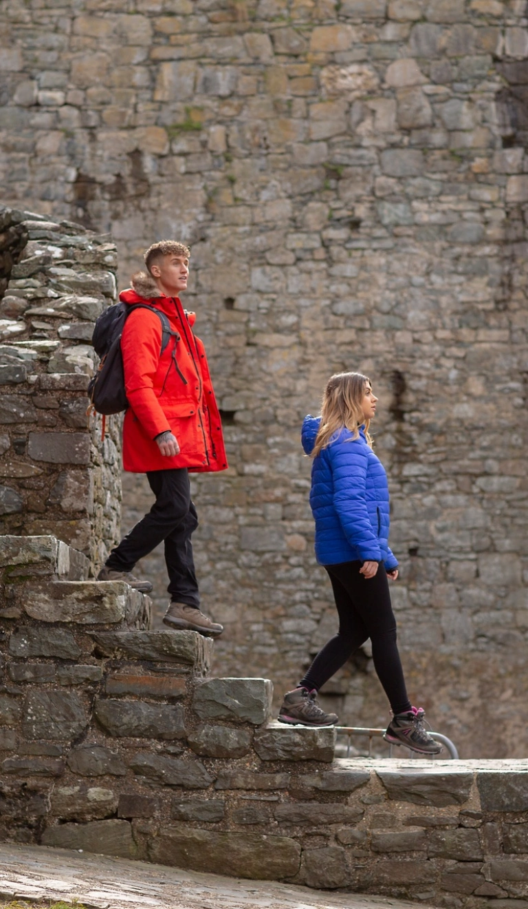 A couple walking down the steps in a castle.