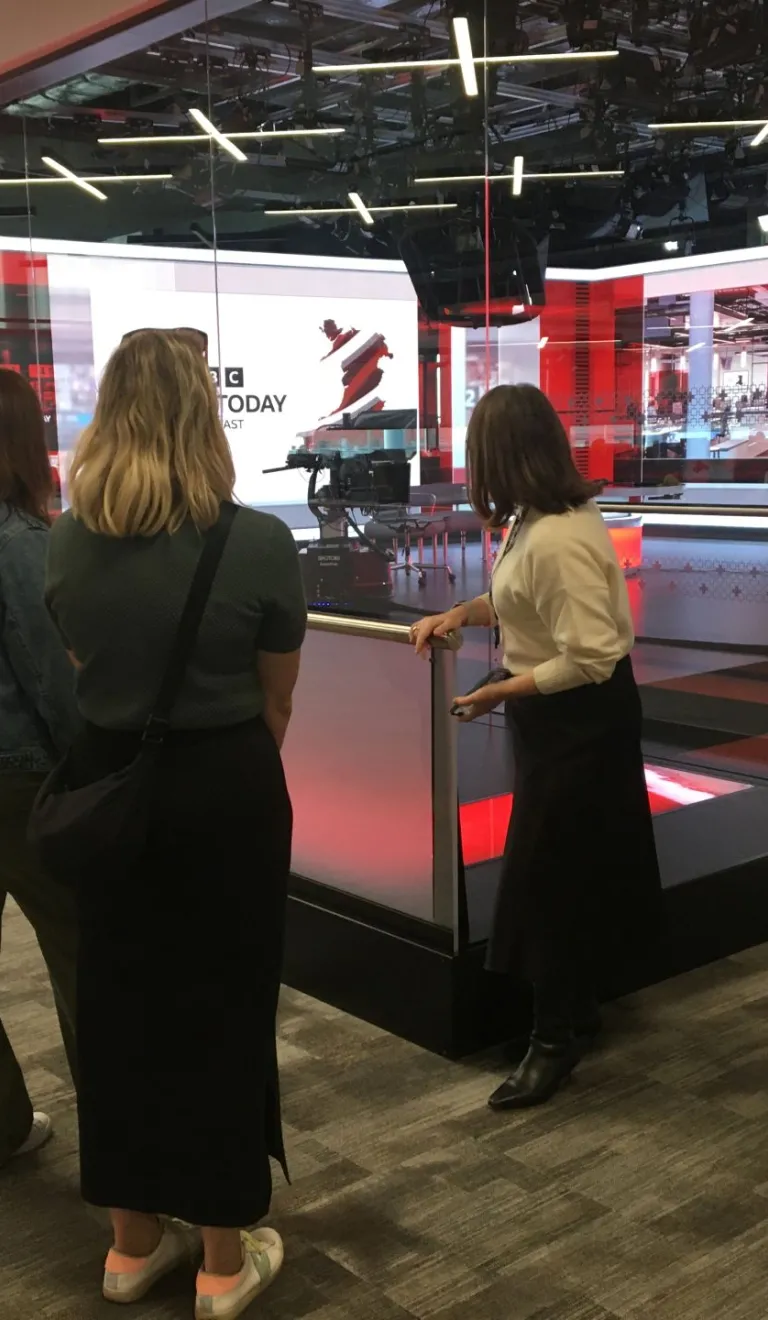 Group on a tour with a guide at a broadcasting studio.